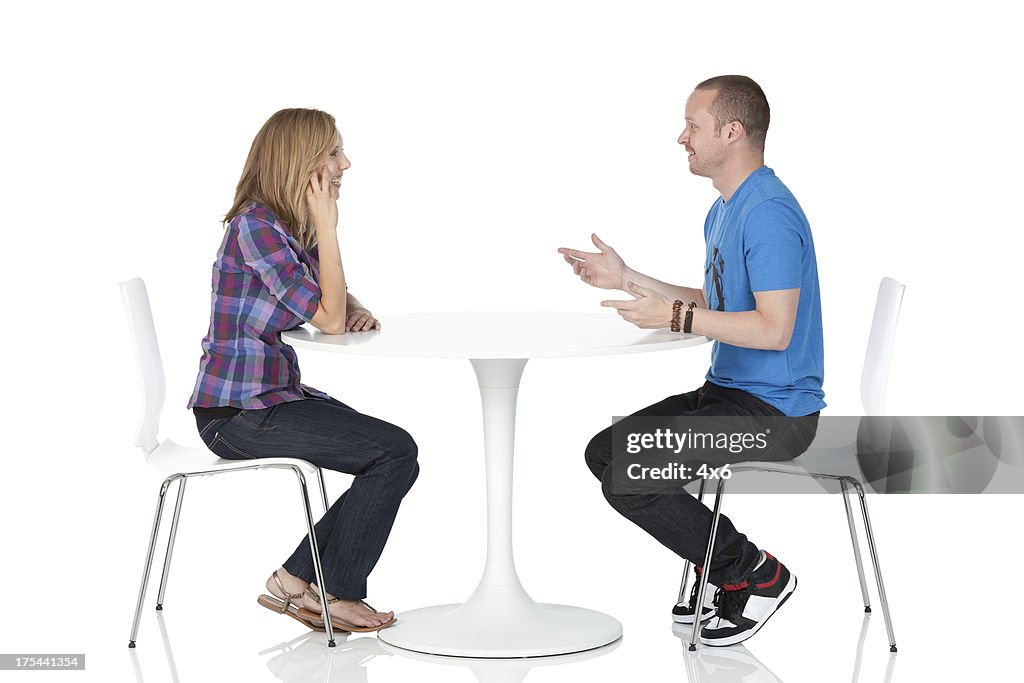 Couple sitting across from one another at a table