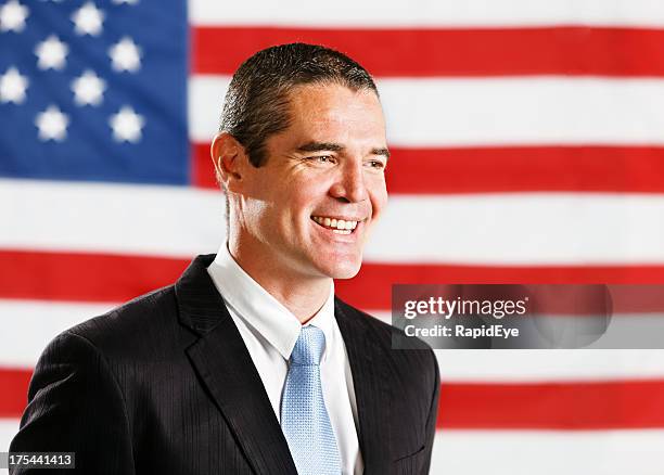 handsome confident-looking businessman in front of us flag - politician portrait stock pictures, royalty-free photos & images