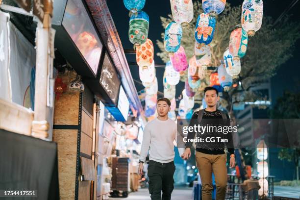 asian chinese gay couple tourist exploring tainan city street at night - tainan stock pictures, royalty-free photos & images