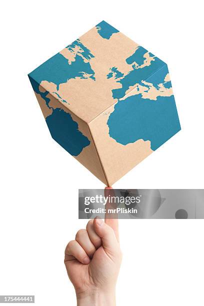 worldwide parcel delivery cardboard box and world map - world at your fingertips stockfoto's en -beelden