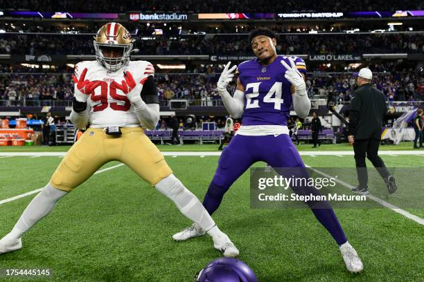 Drake Jackson of the San Francisco 49ers and Camryn Bynum of the Minnesota Vikings pose on the field after the game at U.S. Bank Stadium on October...