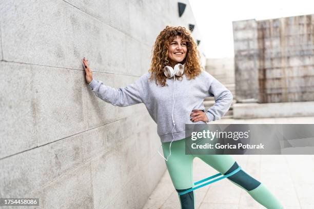 woman exercising outdoors with resistance band around thighs - thigh human leg imagens e fotografias de stock