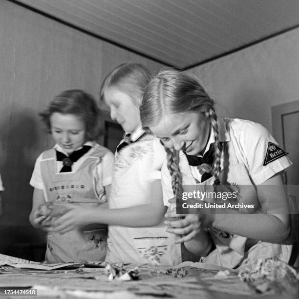 BdM girls peeling potatoes as preparation for the catering of a folcloristic soiree at Berlin Pankow, Germany 1930s.