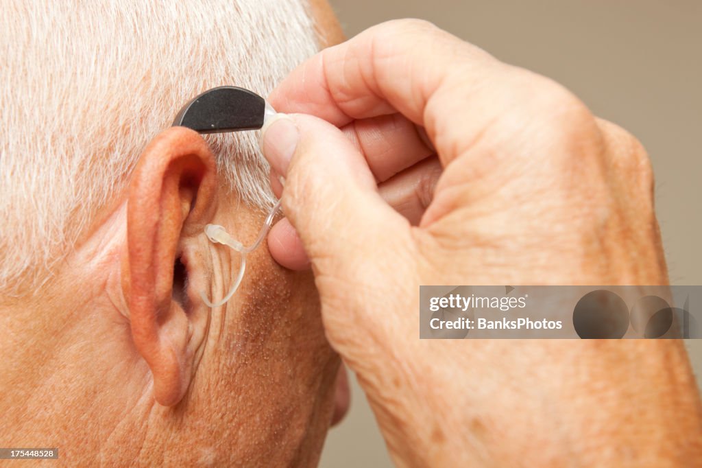 Senior Man Installing Hearing Aid