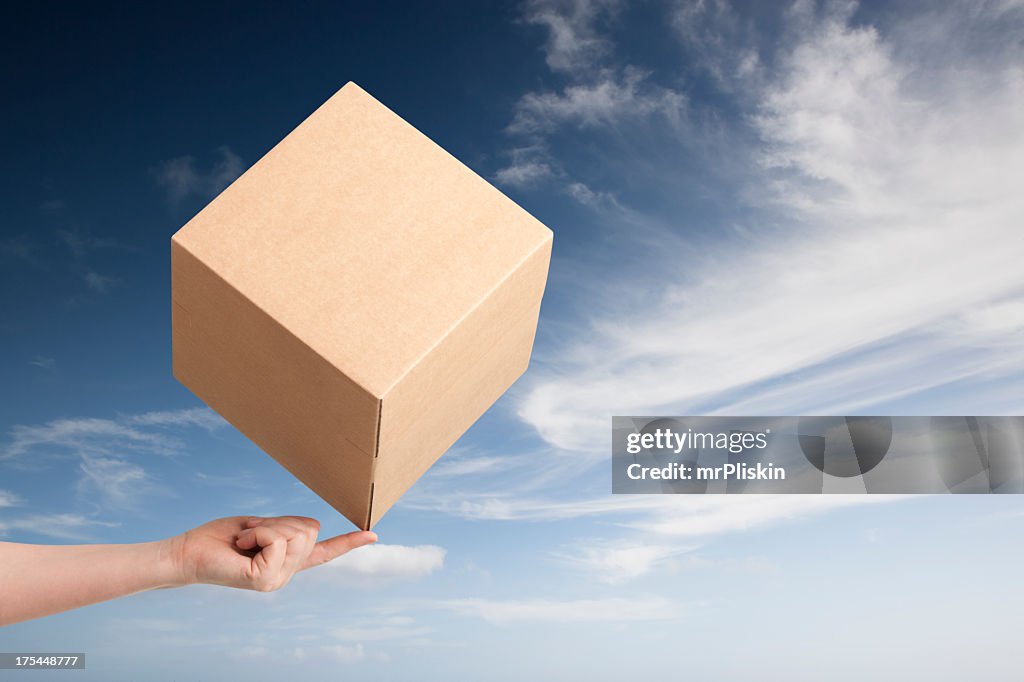 Cardboard box balancing on fingertip