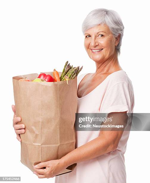 senior woman holding a bag of fresh groceries - isolated - groceries isolated stock pictures, royalty-free photos & images