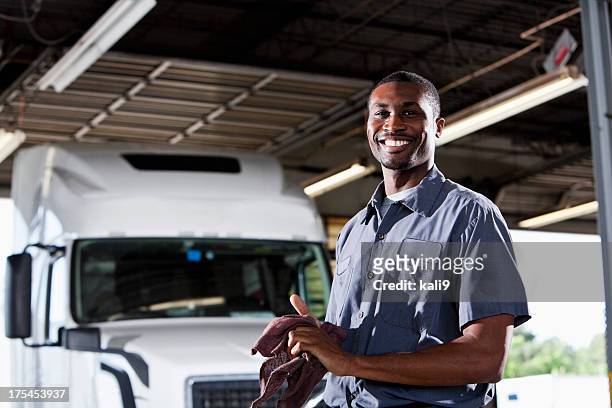 mechanic in garage with semi-truck - rubbing hands together stock pictures, royalty-free photos & images