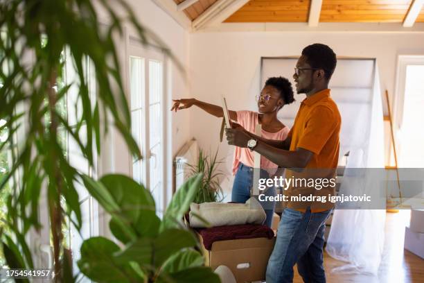 couple arranging new home - home improvement stock pictures, royalty-free photos & images