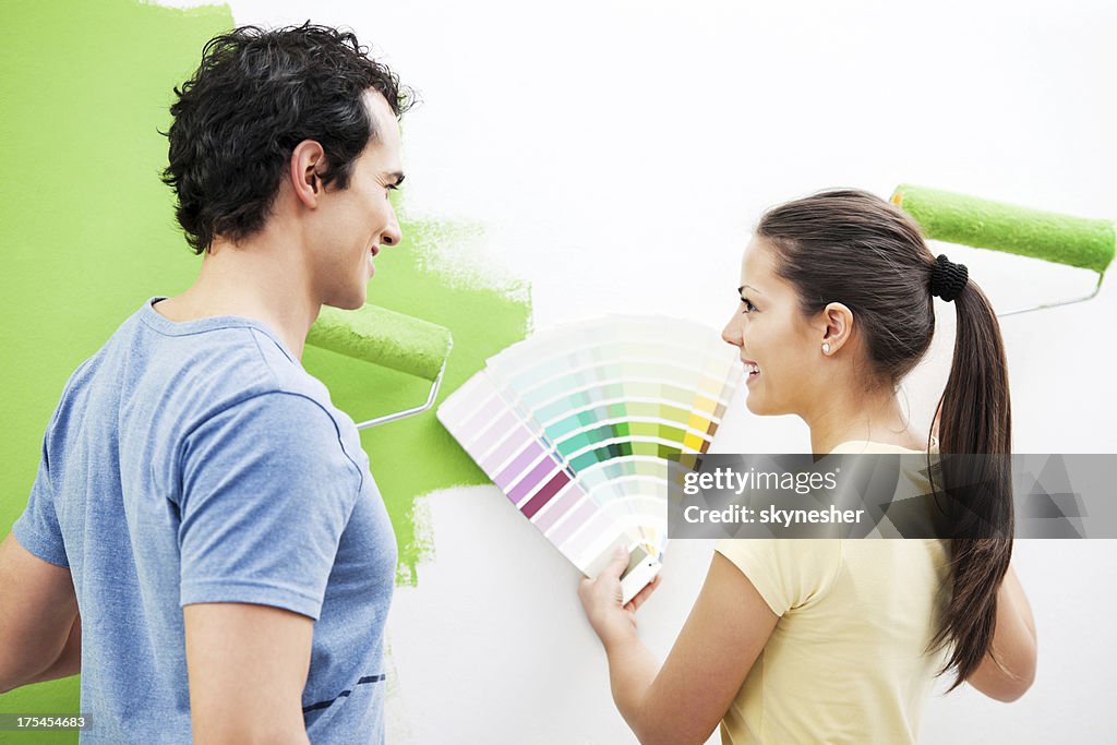 Happy couple choosing color for the wall