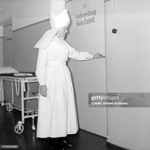 Hospital, run by nuns, here: a nun at her daily business, Germany 1950s.