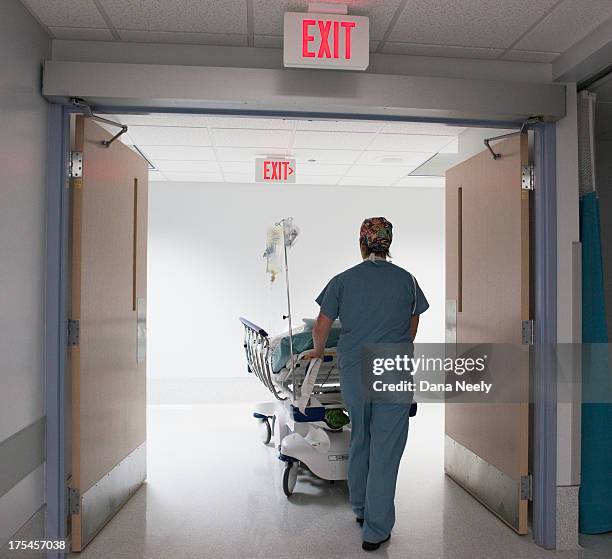 nurse pushing patient into surgery. - hospital bed stockfoto's en -beelden