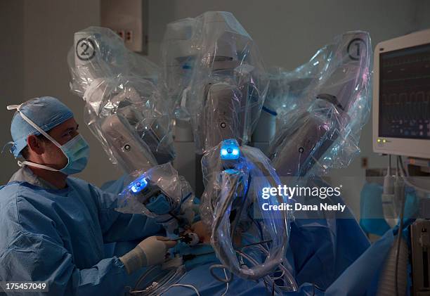 surgeon performing robotic surgery. - surgical robot stock pictures, royalty-free photos & images