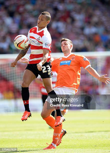 Robert Harris of Blackpool is challenged by Kyle Bennett of Doncaster during the Sky Bet Championship match between Doncaster Rovers and Blackpool at...