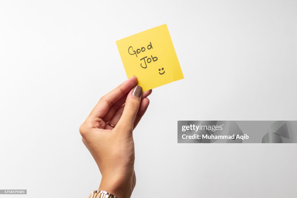 Close-up Of Hand holding sticky note