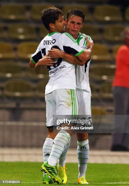 Diego of Wolfsburg celebrates his team's second goal with team mate Christian Traesch during the DFB Cup first round match between Karlsruher SC and...