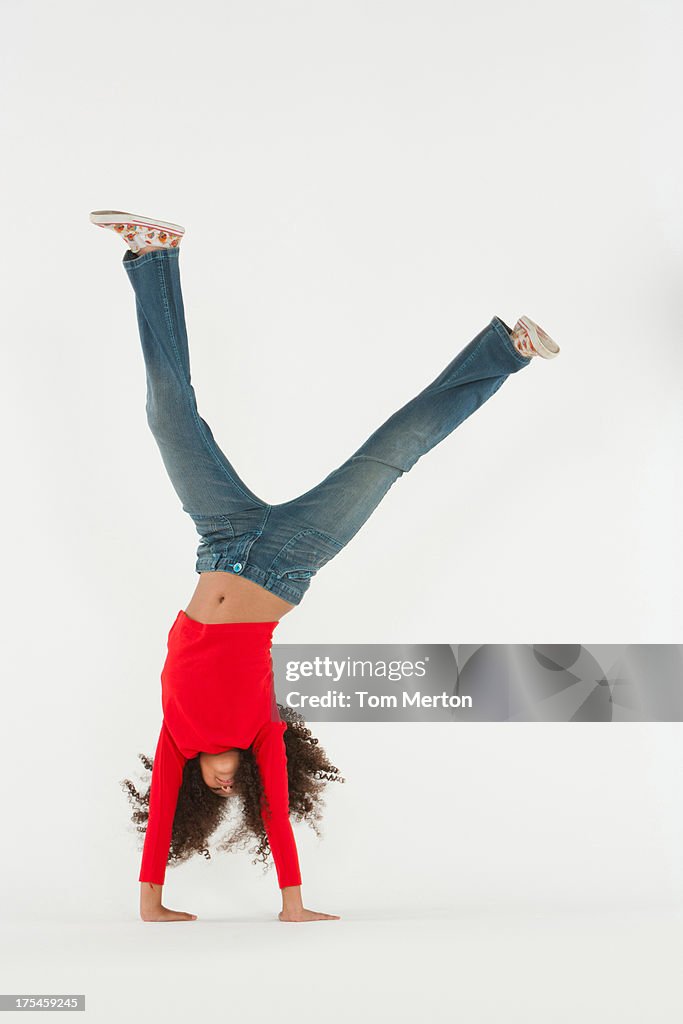 Young girl doing cartwheel indoors