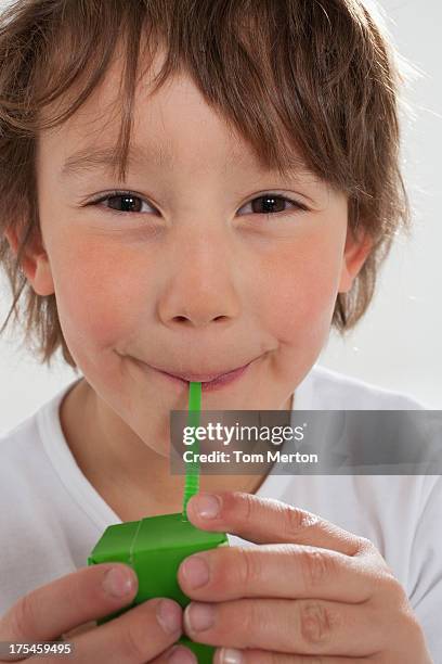 young boy drinking juice box indoors - juice box stock pictures, royalty-free photos & images