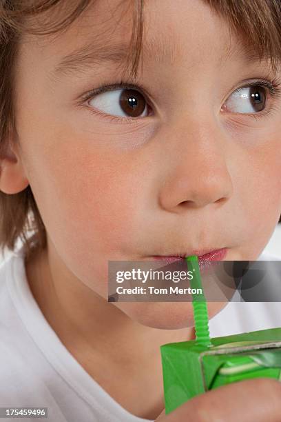 young boy drinking juice box indoors - juice box stock pictures, royalty-free photos & images