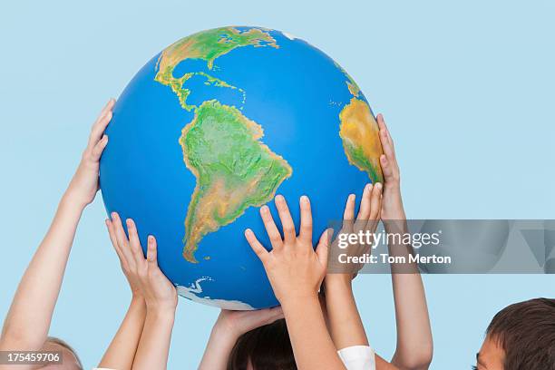 five children's hands indoors touching a globe - child globe bildbanksfoton och bilder