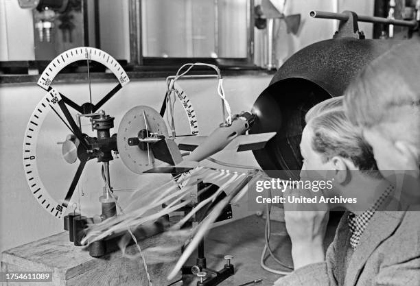 Pilot trainees studying the steering of a plane by observing a model, Germany 1930s.