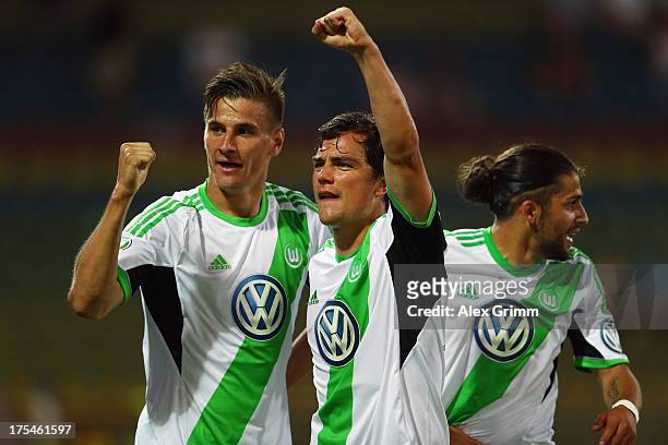 Marcel Schaefer of Wolfsburg celebrates his team's third goal with team mates Stefan Kutschke and Ricardo Rodriguez during the DFB Cup first round...