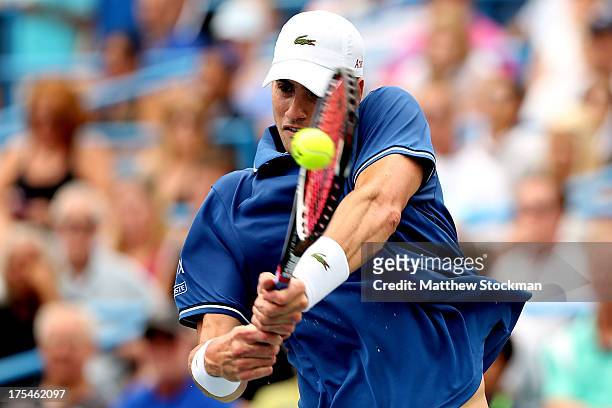 John Isner returns a shot to Dmitry Tursunov of Russia during the semifinals of the Citi Open at the William H.G. FitzGerald Tennis Center on August...