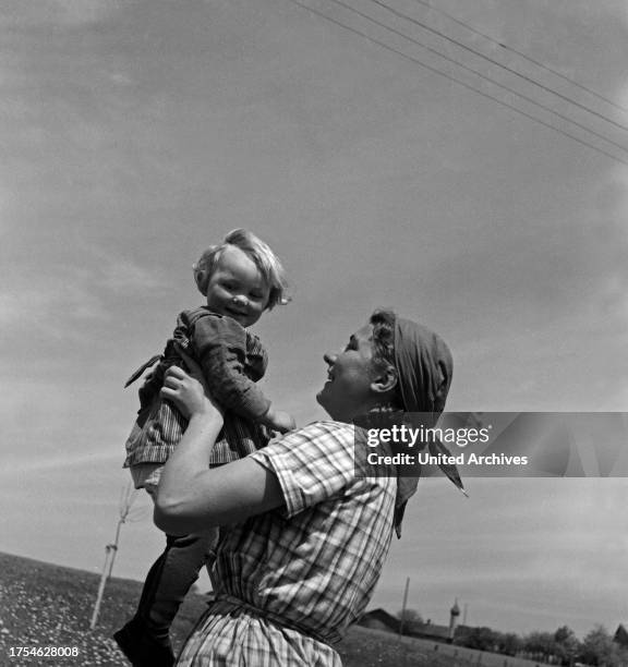 Young woman holding a toddler at Hohenaschau at Frauenarbeitsdienst female workforce, Germany 1930s.