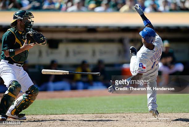 Jurickson Profar of the Texas Rangers dives backwards out of the way of a pitch caught by Derrick Norris and thrown by Grant Balfour of the Oakland...