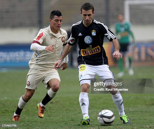 Horacio Calcaterra of Sporting Cristal fights for the ball with Carlos Olascuaga of Universitario during a match between Universitario and Sporting...