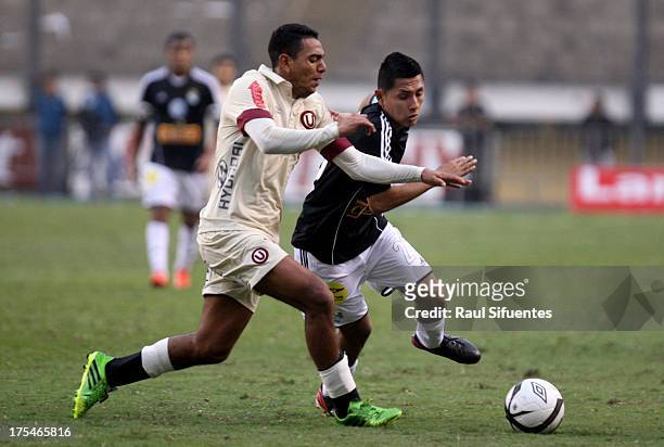 Irvin Acuna of Sporting Cristal fights for the ball with Nestor Duarte of Universitario during a match between Universitario and Sporting Cristal as...