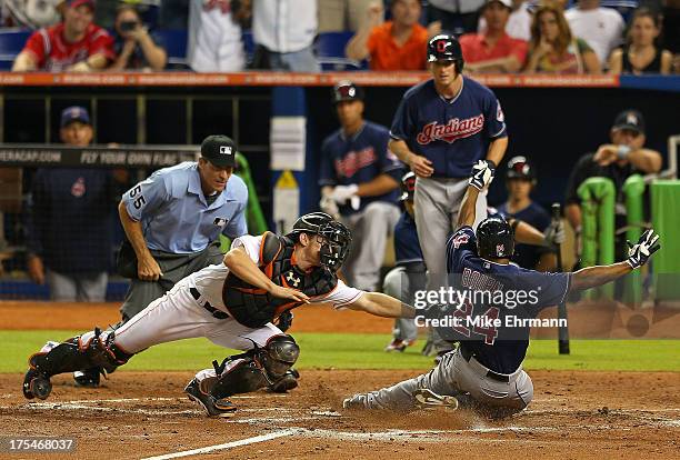 Michael Bourn of the Cleveland Indians slides past the tag from Rob Brantly of the Miami Marlins during a game at Marlins Park on August 3, 2013 in...