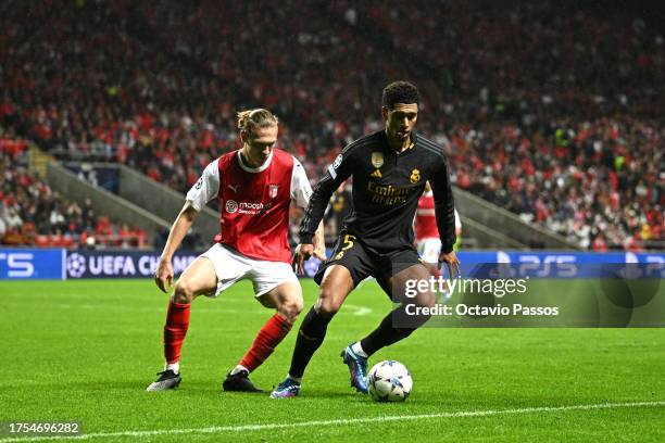 Jude Bellingham of Real Madrid runs with the ball whilst under pressure from Serdar Saatci of SC Braga during the UEFA Champions League match between...