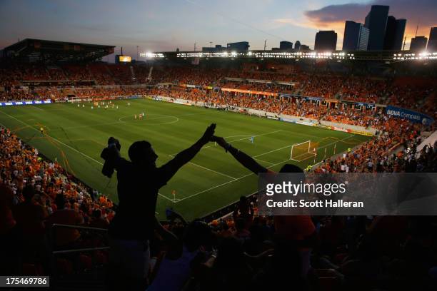 Dynamo fans celebrate after Brad Davis of the Houston Dynamo scored a first half goal against the Columbus Crew at BBVA Compass Stadium on August 3,...
