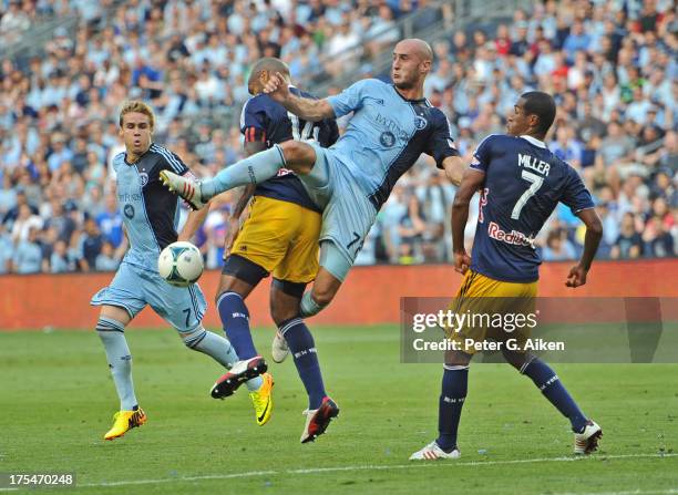 Defender Aurelien Collin of Sporting Kansas City goes for the ball against pressure from forward Thierry Henry of the New York Red Bulls during the...