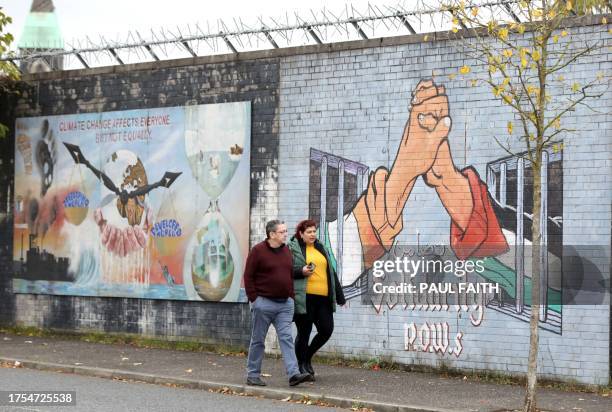 People pass a pro-Palestinian mural on the Republican Falls Road in Belfast on October 23, 2023. Northern Ireland may be thousands of miles from the...