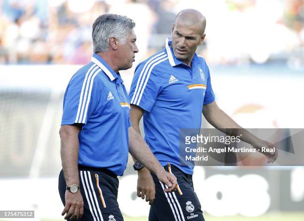 Head coach Carlo Ancelotti of Real Madrid talks with his assistant Zinedine Zidane during the International Champions Cup 2013 match between Everton...