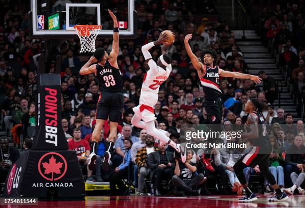 Chris Boucher of the Toronto Raptors goes to the basket against Toumani Camara , Shaedon Sharpe , and Jabari Walker of the Portland Trail Blazers...