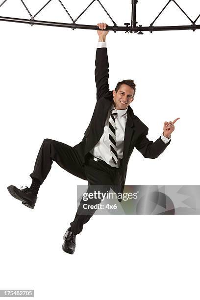 businessman hanging from a metal structure - suits hanging stock pictures, royalty-free photos & images