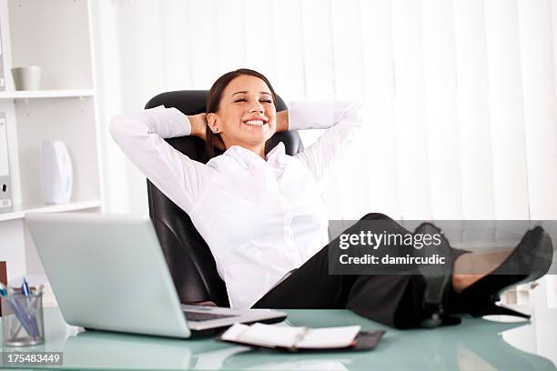 giovane donna d'affari rilassanti in ufficio - legs on the table foto e immagini stock