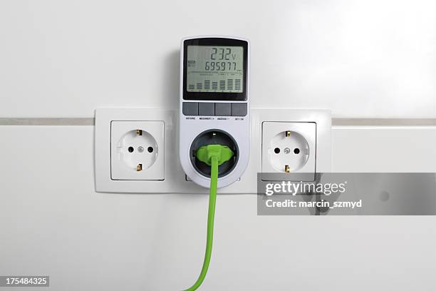 green electric plug and electricity analyzer - meter stock pictures, royalty-free photos & images