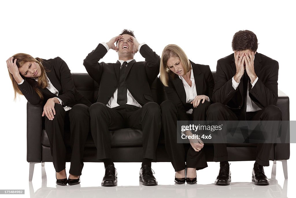 Irritated business executives sitting on a couch