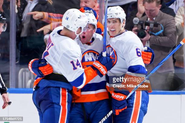 Casey Cizikas of the New York Islanders is congratulated by Bo Horvat and Ryan Pulock after scoring a goal against the Detroit Red Wings during the...
