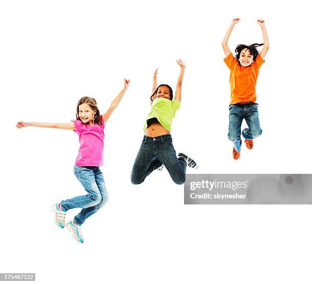 cheerful kids jumping with arms up. - kid jump stock pictures, royalty-free photos & images