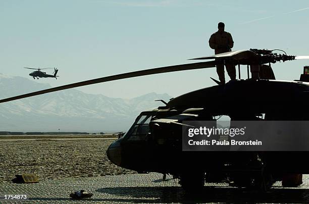 Army 82nd Airborne soldier performs routine repairs on a MH-60 Blackhawk helicopter while on the flight deck at Bagram military base January 31, 2003...