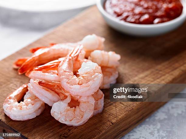 cooked shrimps on wooden board next to red sauce - prawn cocktail stock pictures, royalty-free photos & images