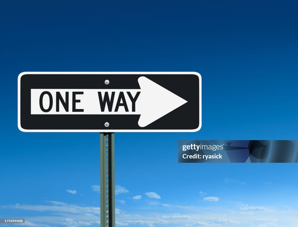 One Way Sign Post Pointing Right Over a Sky Background