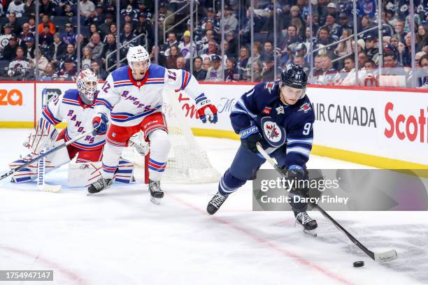 Cole Perfetti of the Winnipeg Jets plays the puck as Nick Bonino of the New York Rangers gives chase during first period action at the Canada Life...