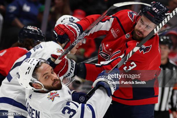 Tom Wilson of the Washington Capitals checks Timothy Liljegren of the Toronto Maple Leafs during the second period at Capital One Arena on October...