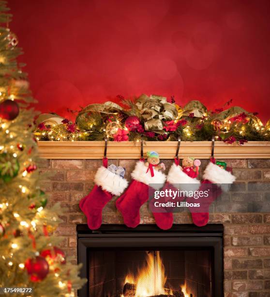 fireplace decorated for christmas - stockings stockfoto's en -beelden