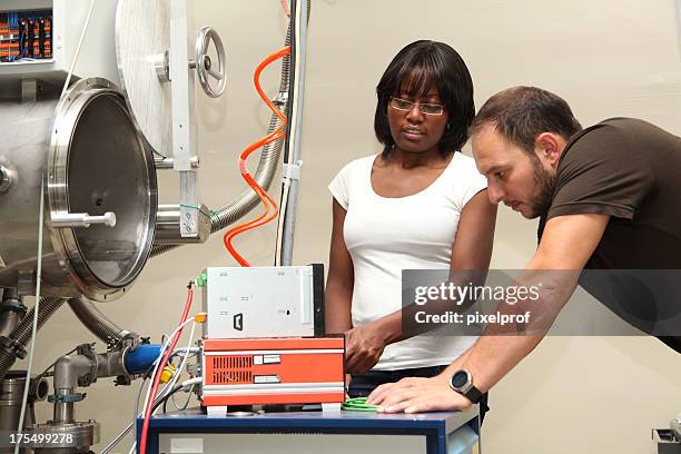 young scientists in research laboratory - physicist stock pictures, royalty-free photos & images